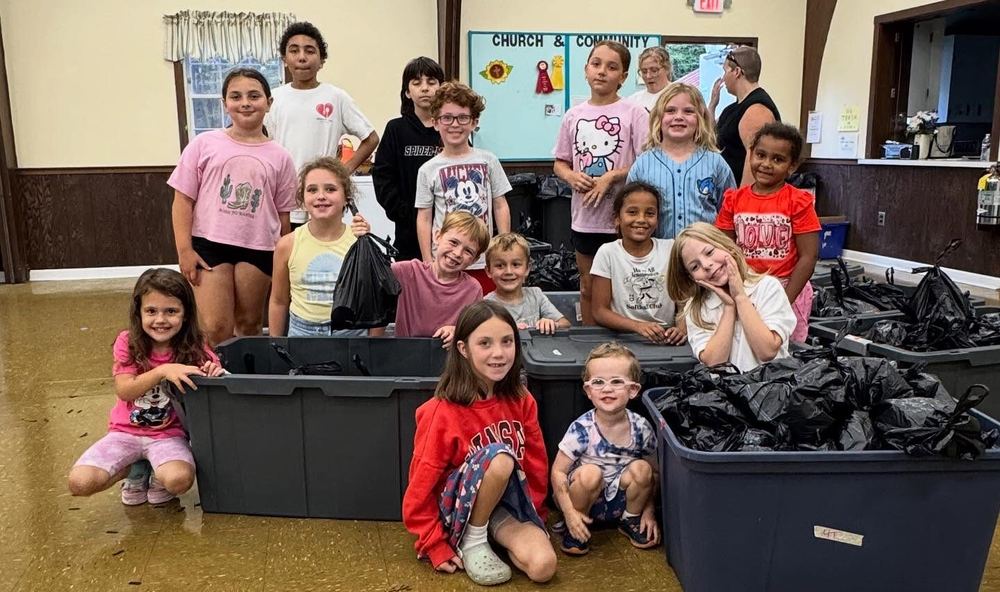 Kids with bins of packed food bags